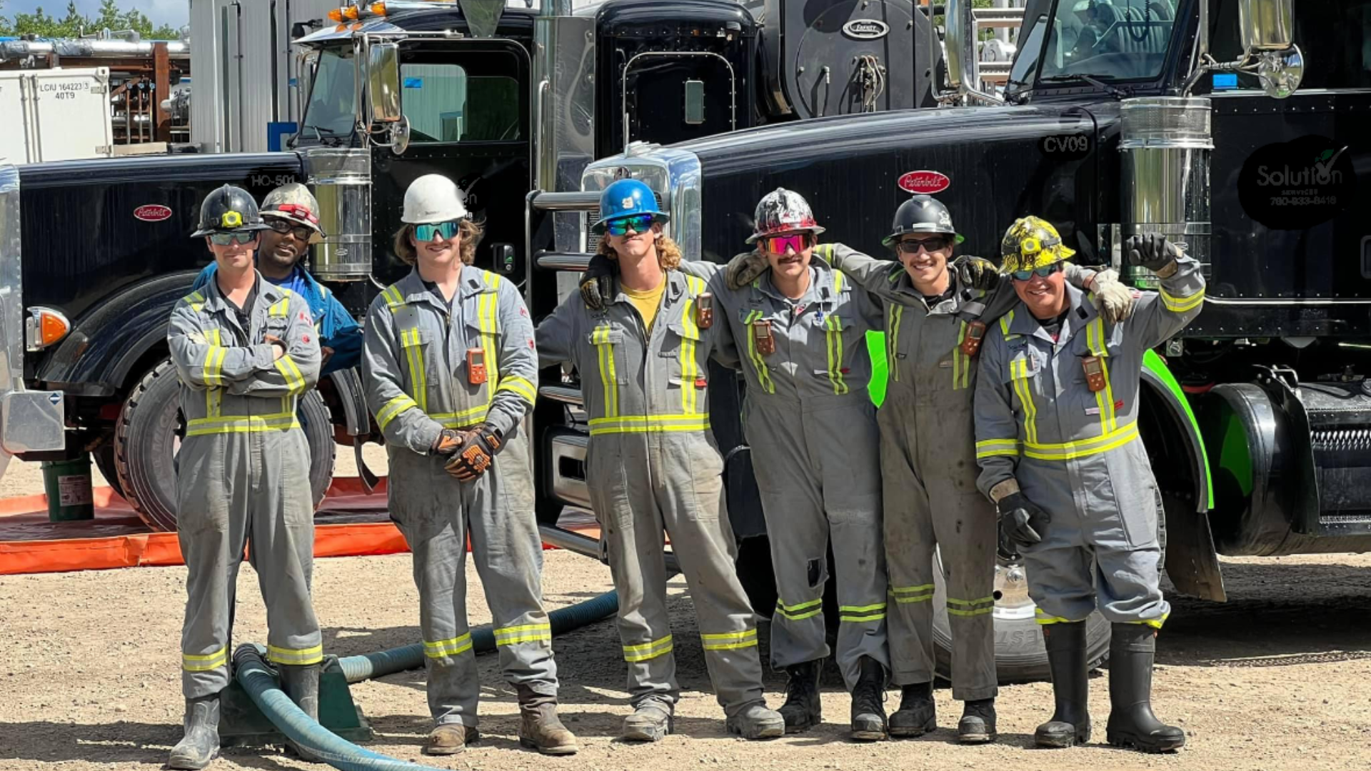 Team member in truck cab wearing high-visibility work gear